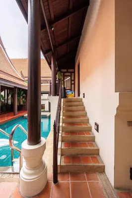 a staircase leading to a swimming pool next to a house at CBD Private Pool Villa Nanny Free Thai costumes 24hrs Security Breakfast in Bangkok