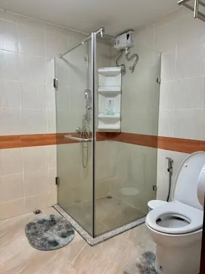 a bathroom with a shower and a toilet at Baan Kalaya Homestay in Nonthaburi