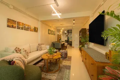 a living room with a couch and a tv at Oasis Thai Teak Home in Sathorn in Yan Nawa