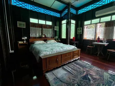 a bedroom with a bed and a table and windows at นำสมัย สุขใจ สนามชัย in Bangkok