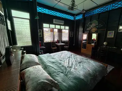 a bedroom with a large bed in a room with windows at นำสมัย สุขใจ สนามชัย in Bangkok