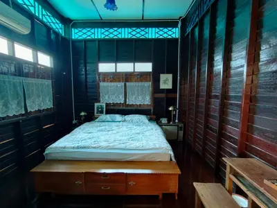 a bedroom with a bed in a room with wooden walls at นำสมัย สุขใจ สนามชัย in Bangkok