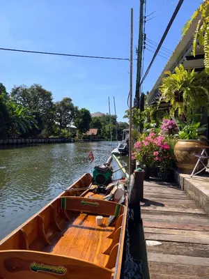 a wooden boat is docked next to a dock at นำสมัย สุขใจ สนามชัย in Bangkok