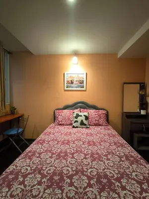a bedroom with a red bed with a pillow on it at Santo house no66 in Bangkok
