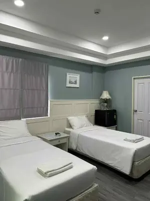 two beds in a room with blue walls at 101Hotel in Ban Na Song