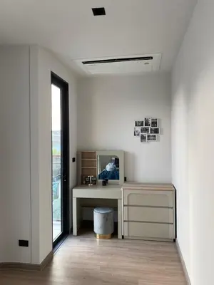 a white room with a desk and a mirror at 89 Residence Ratchada - Rama 9 in Ban Na Song