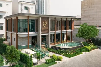 a building with a swimming pool in front of a building at 89 Residence Ratchada - Rama 9 in Ban Na Song