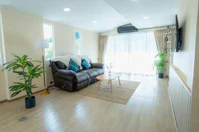 a living room with a leather couch and a table at Stay Ekkamai - Private Pool villa, Central Bangkok in Bangkok