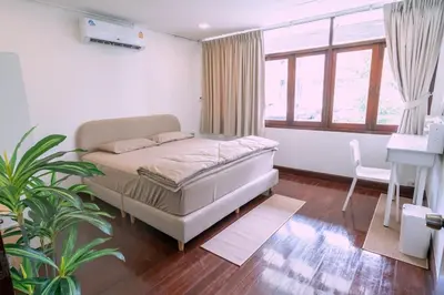 a bedroom with a bed and a plant in it at Stay Ekkamai - Private Pool villa, Central Bangkok in Bangkok