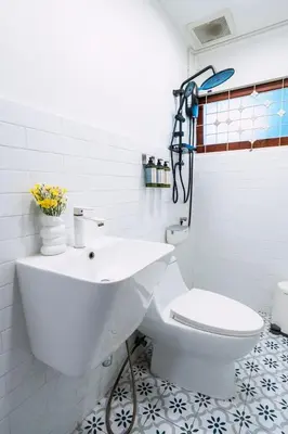 a white bathroom with a toilet and a sink at Stay Ekkamai - Private Pool villa, Central Bangkok in Bangkok