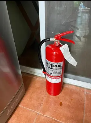 a red fire extinguisher sitting on the floor next to a window at 38 House Don Mueang Airport BTS Wat Phrasi in Bang Khen