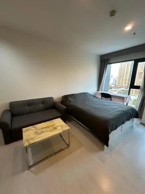 a bedroom with a bed and a couch and a table at BTS Skytrain Thonglor station sukhumwit 36-38 in Bangkok