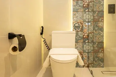 a white toilet in a bathroom with a phone at Cute & Comfy Studio for 3 guests at Center of Sathorn in Bangkok