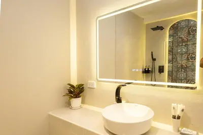 a bathroom with a white sink and a mirror at Cute & Comfy Studio for 3 guests at Center of Sathorn in Bangkok