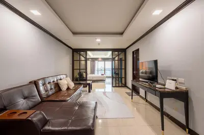 a living room with a leather couch and a television at Hangover State Tower Stunning River View in Bangkok