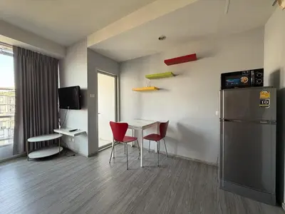 a room with a table and chairs and a refrigerator at Pano Ratchada 19 BKK MRT in Bangkok