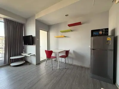 a room with a table and chairs and a refrigerator at Pano Ratchada 19 BKK MRT in Bangkok