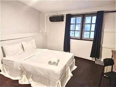 a bedroom with a white bed with a pair of engagement rings at Znap Yaowarat - MRT Wat Mangkon in Samphanthawong
