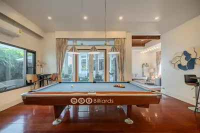 a pool table in the middle of a living room at Thong Lo Private Pool Villa In Center Of Bangkok in Bangkok