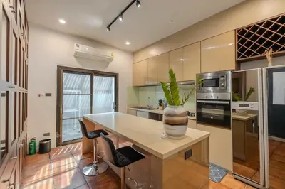 a kitchen with a island with a plant in a vase at Thong Lo Private Pool Villa In Center Of Bangkok in Bangkok
