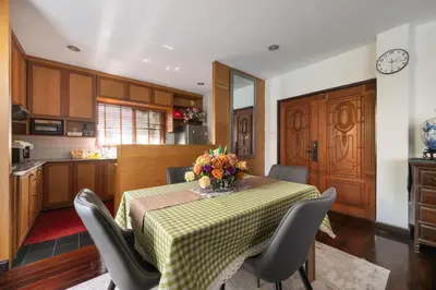 a kitchen with a table with a vase of flowers on it at Star House Classic Style in Bangkok