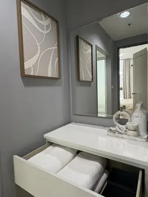 a bathroom with a vanity with a mirror and white towels at Ideo Mix Sukhumvit 103, right next to BTS Udomsuk in Phra Khanong