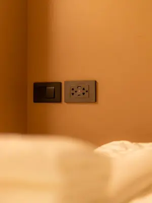 a bedroom with an electrical outlet on the wall at Social Pod Khao San Hostel in Bangkok