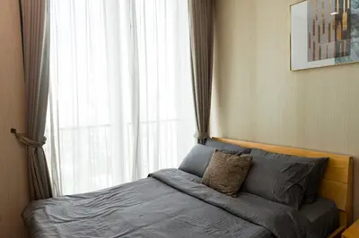 a bedroom with a bed with a window and a pillow at Lux Condo 2BR - 5 mins walk to BTS Phrom Phong in Bangkok