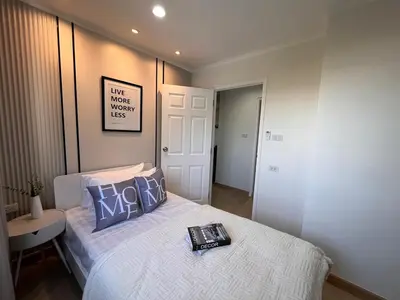a bedroom with a bed with a book on it at Cozy style 2BR 2B near street food in city in Bangkok