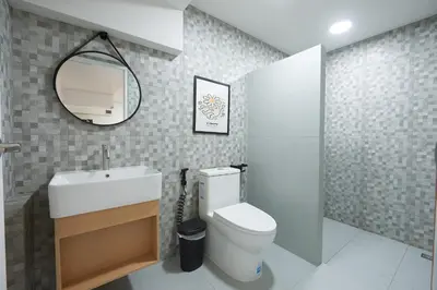 a bathroom with a white toilet and a mirror at Arta House in Bangkok