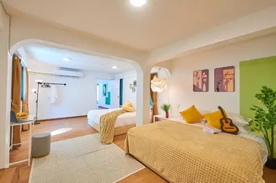 a bedroom with two beds and a guitar in it at Arta House in Bangkok