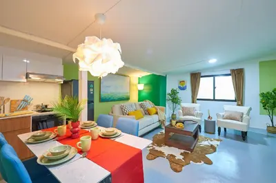 a living room with a dining table and a kitchen at Arta House in Bangkok