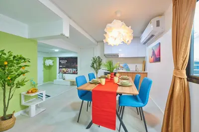 a dining room with a red table and blue chairs at Arta House in Bangkok