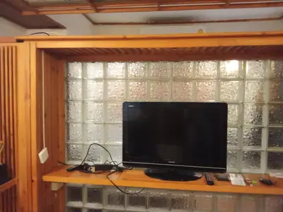 a television sitting on a shelf in front of a window at Spacious City-View Apartment with Modern Amenities in Krung Thep in Amphoe Phra Khanong