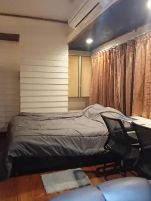 a bedroom with a bed and a table and chairs at Spacious City-View Apartment with Modern Amenities in Krung Thep in Amphoe Phra Khanong