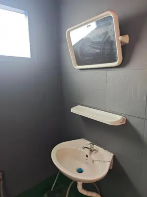 a bathroom with a sink and a mirror on the wall at Worsakornrit Homestay in Bangkok