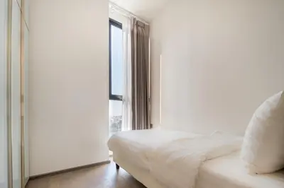 a bedroom with a white bed and a window at Hampton Residence Phayathai in Sathani Sam Sen