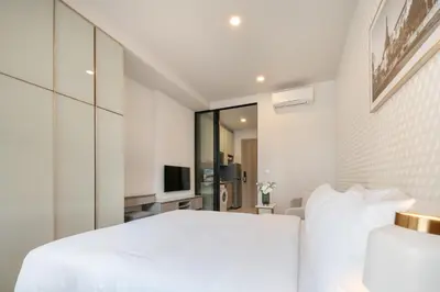 a bedroom with a white bed and a television at Hampton Residence Phayathai in Sathani Sam Sen