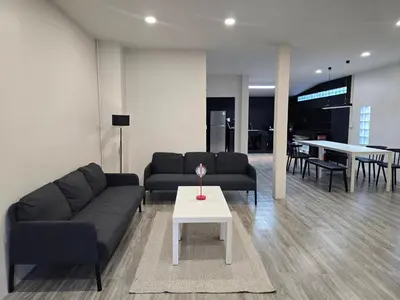 a living room with a couch and a table at Baan White House in Ban Baen Phichit