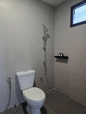 a bathroom with a toilet and a shower at Baan White House in Ban Baen Phichit