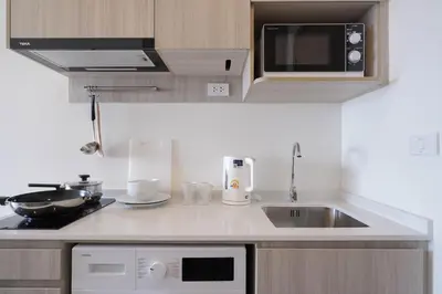 a kitchen with a sink and a microwave at The Hampton Suites Bangna in Bangna