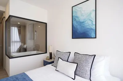 a bedroom with a large mirror above a bed at The Hampton Suites Bangna in Bangna