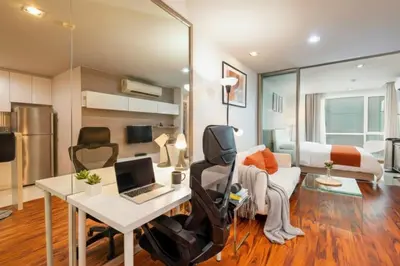 a room with a desk and a bed with a laptop at Designer Home BTS bangkok centre Pool Gym