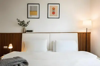 a bedroom with two white beds and two pictures on the wall at Designer Home BTS bangkok centre Pool Gym