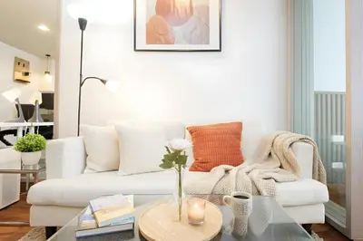a living room with a white couch and a glass table at Designer Home BTS bangkok centre Pool Gym
