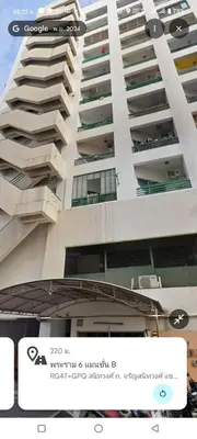 a tall white building with a sign in front of it at Mansion phram6 B in Bangkok