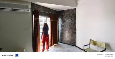 a woman is looking out of a door at Mansion phram6 B in Bangkok