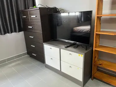 a entertainment center with a flat screen tv on a dresser at Impact Arena C5 by Jintana in Thung Si Kan