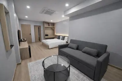 a living room with a couch and a bed at Whiteinn - ไวท์อินน์ in Nonthaburi
