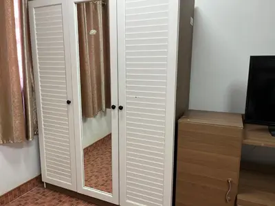 a room with white closet doors and a television at Impact Arena C9 by Jintana in Thung Si Kan